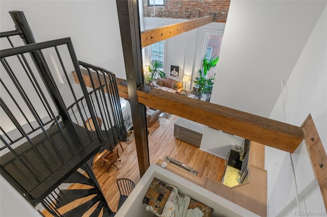 stairs featuring hardwood / wood-style flooring and brick wall