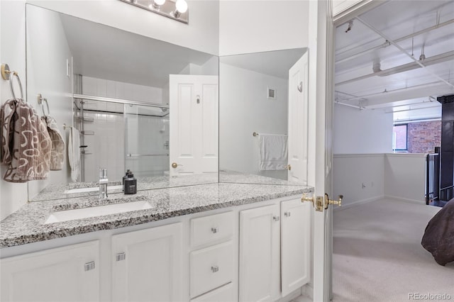 bathroom featuring vanity and an enclosed shower