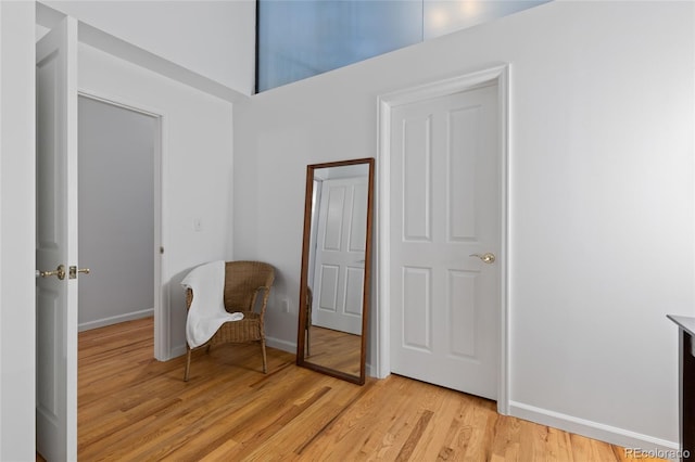 living area with light hardwood / wood-style flooring and a high ceiling