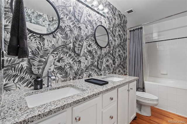 full bathroom with wood-type flooring, shower / bath combo, vanity, and toilet