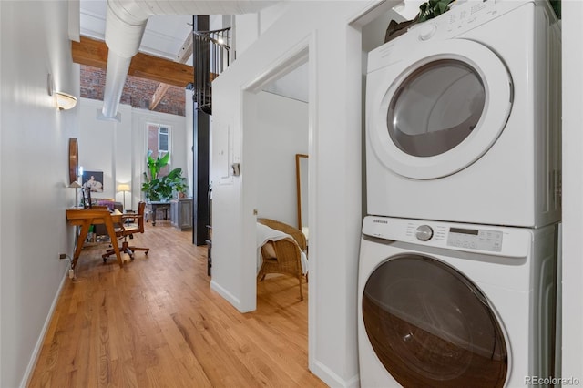 washroom featuring stacked washer and clothes dryer and light hardwood / wood-style floors