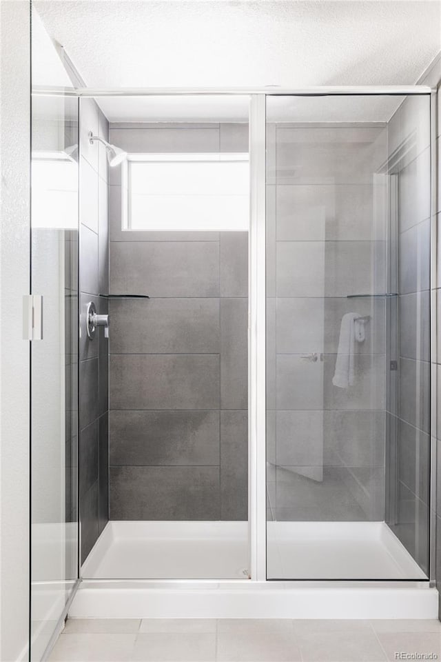 bathroom with walk in shower and a textured ceiling