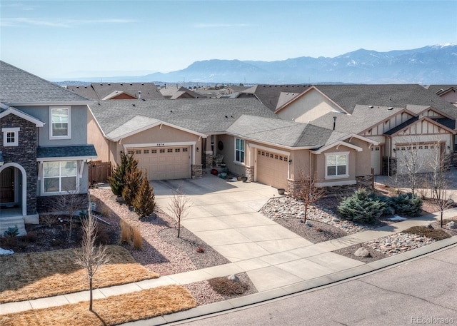 5279 Mount Cutler Ct, Colorado Springs, CO 80924 - view of front of home with stone siding, stucco siding, an attached garage, a mountain view, and driveway