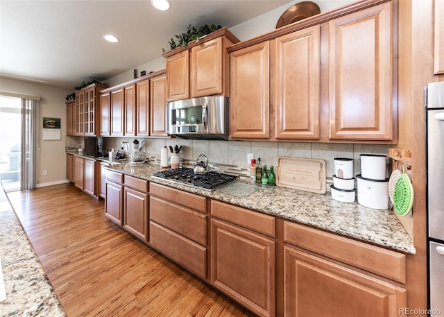 5279 Mount Cutler Ct, Colorado Springs, CO 80924 - kitchen with recessed lighting, decorative backsplash, stainless steel appliances, and light wood-type flooring