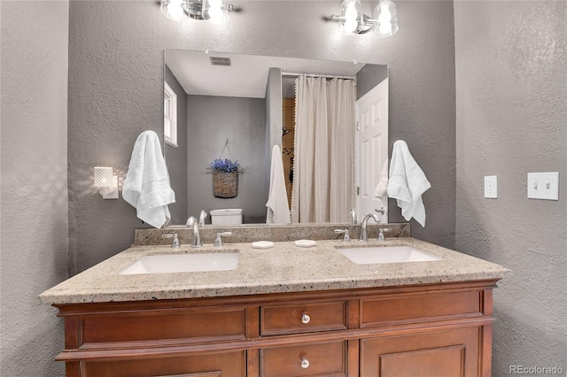 4782 E Costilla Ave, Centennial, CO 80122 - bathroom featuring a textured wall, double vanity, and toilet