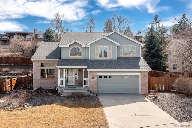 traditional home featuring concrete driveway, an attached garage, fence, and roof with shingles