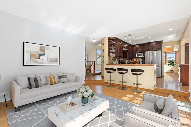 living area with stairway and light wood-style floors