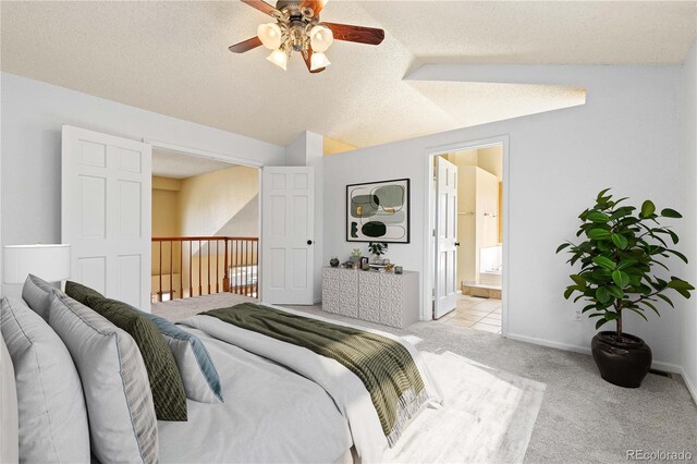 bedroom with baseboards, light colored carpet, lofted ceiling, ensuite bath, and a textured ceiling