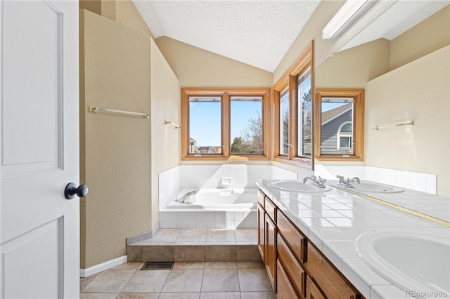 full bath with a sink, a textured ceiling, a bath, and vaulted ceiling