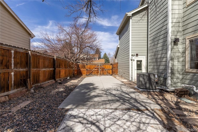 view of patio with a gate, central AC unit, and fence