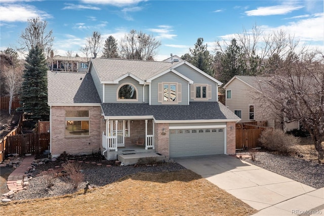 traditional-style home with brick siding, roof with shingles, a garage, and fence