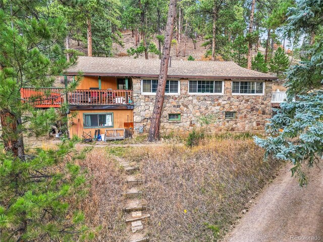 rear view of house featuring a wooden deck