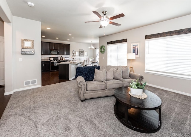 9835 Rubicon Dr, Colorado Springs, CO 80925 - living room with dark colored carpet, ceiling fan, a chandelier, recessed lighting, and baseboards