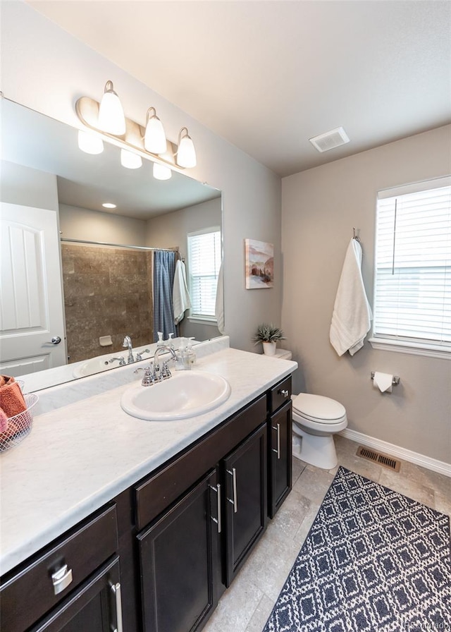 9835 Rubicon Dr, Colorado Springs, CO 80925 - bathroom with vanity, a tile shower, toilet, tile patterned floors, and baseboards
