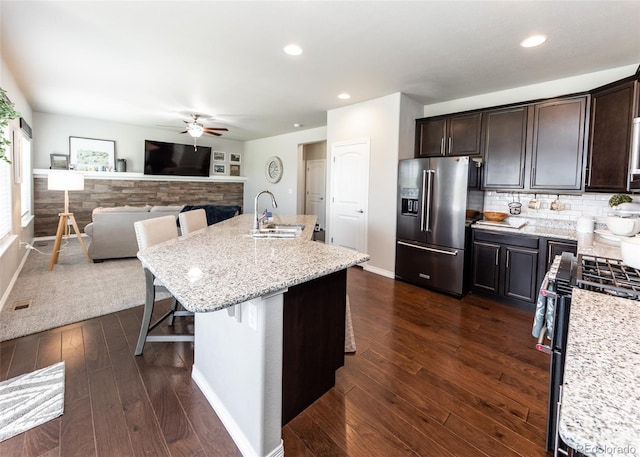 9835 Rubicon Dr, Colorado Springs, CO 80925 - kitchen with appliances with stainless steel finishes, a sink, a ceiling fan, a breakfast bar area, and dark wood-type flooring