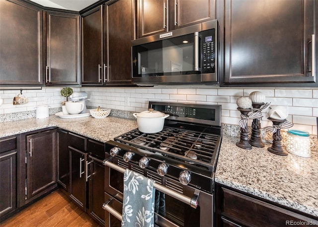 9835 Rubicon Dr, Colorado Springs, CO 80925 - kitchen featuring stainless steel range with gas stovetop, light stone counters, and dark brown cabinets
