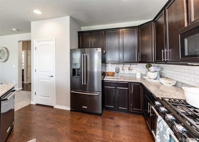 9835 Rubicon Dr, Colorado Springs, CO 80925 - kitchen featuring appliances with stainless steel finishes, light stone countertops, backsplash, dark wood finished floors, and recessed lighting