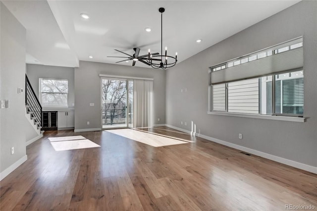 interior space featuring hardwood / wood-style floors and ceiling fan with notable chandelier