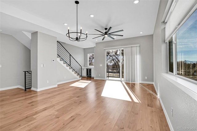 foyer featuring ceiling fan with notable chandelier and light hardwood / wood-style floors