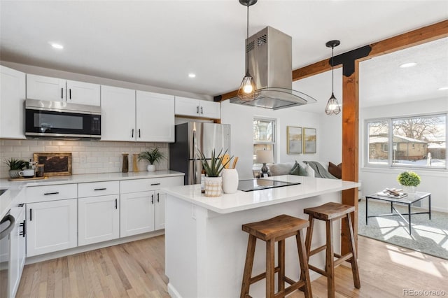 kitchen featuring stainless steel appliances, island range hood, and white cabinets