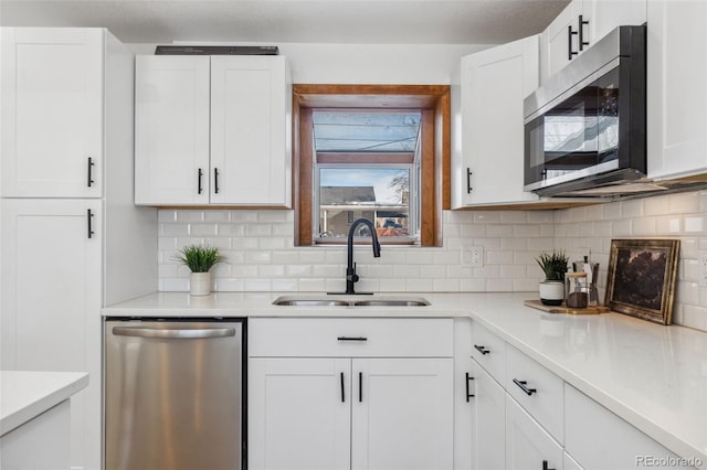 kitchen featuring tasteful backsplash, appliances with stainless steel finishes, sink, and white cabinets