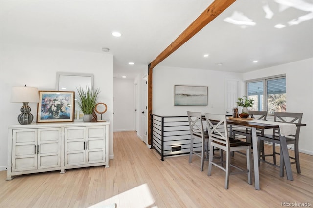 dining space with beam ceiling and light wood-type flooring