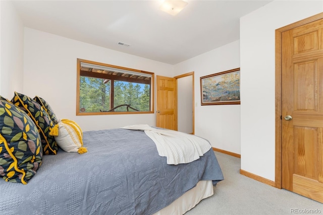 bedroom with light carpet, visible vents, and baseboards