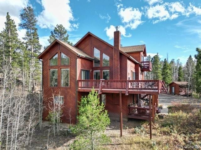 back of property featuring a wooden deck and a chimney