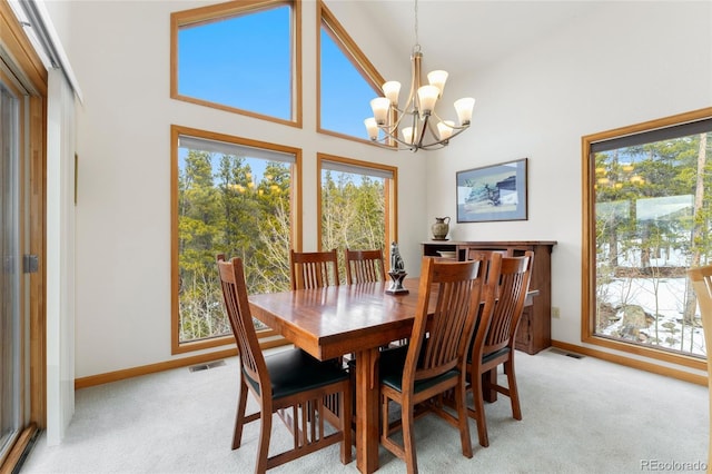 dining room featuring a wealth of natural light, a notable chandelier, and light colored carpet