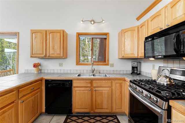kitchen featuring plenty of natural light, light brown cabinets, a sink, and black appliances