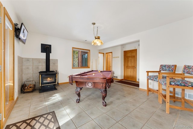 rec room featuring light tile patterned floors, a wood stove, billiards, and baseboards
