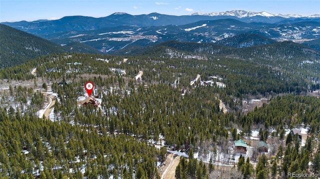 birds eye view of property with a forest view and a mountain view