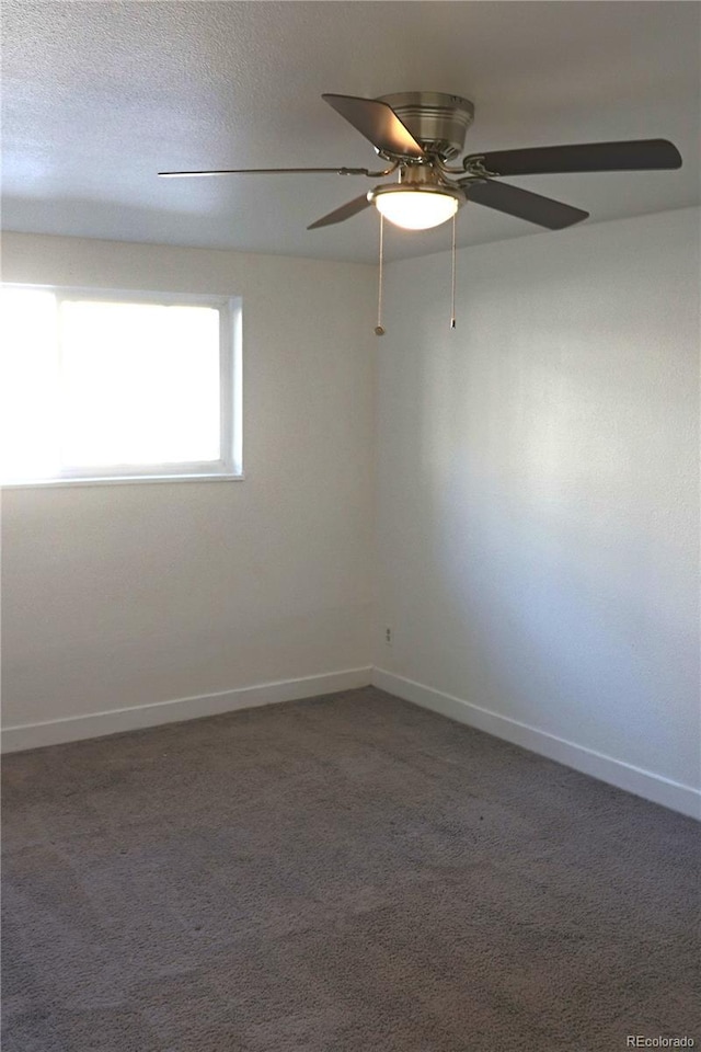 carpeted spare room featuring ceiling fan