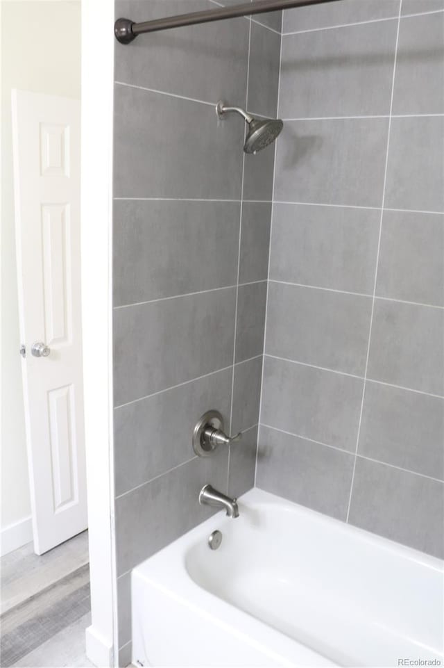 bathroom featuring tiled shower / bath combo and hardwood / wood-style flooring