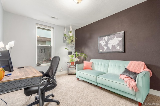 office area featuring an accent wall, carpet, visible vents, and baseboards