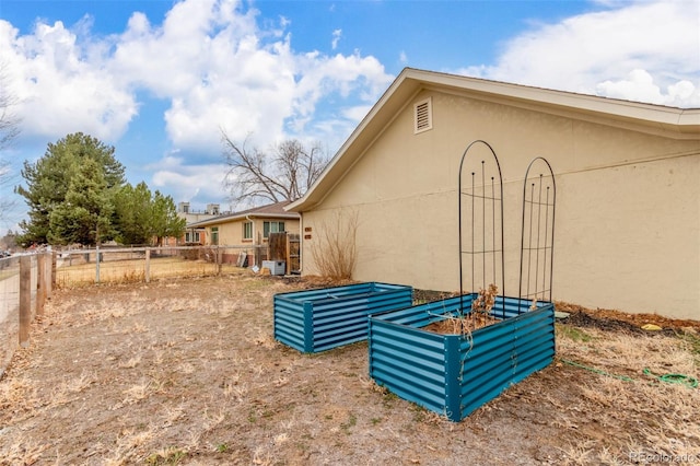 view of side of property featuring central air condition unit, fence, and stucco siding