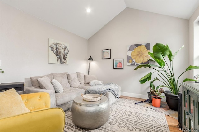 living room with vaulted ceiling, wood finished floors, and baseboards