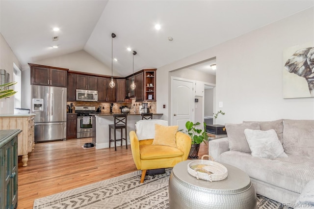 living room with vaulted ceiling, recessed lighting, and light wood-style floors