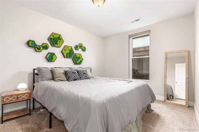 carpeted bedroom with visible vents and baseboards