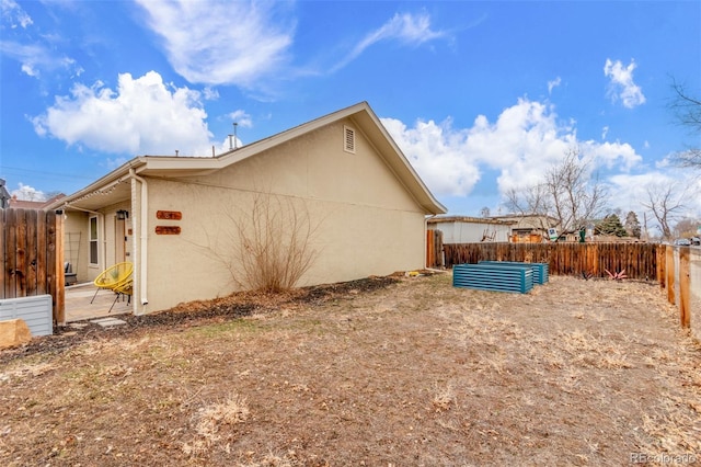 view of home's exterior featuring a patio area, fence, and stucco siding