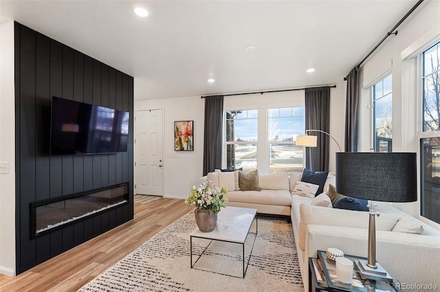 living room with a wealth of natural light, light wood-style flooring, and recessed lighting