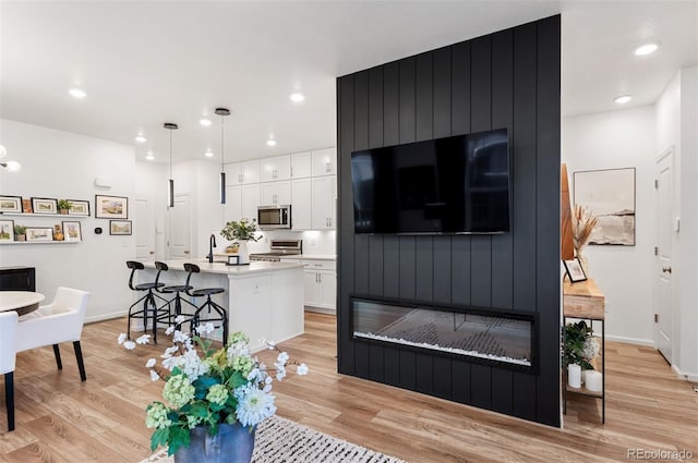 living area featuring light wood-style flooring and recessed lighting