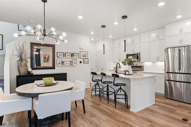 dining space with light wood finished floors and recessed lighting