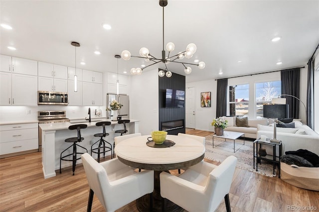 dining space featuring light wood finished floors and recessed lighting