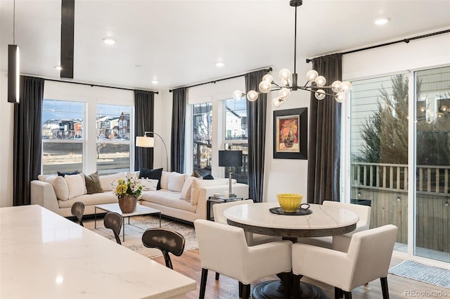 dining space featuring a notable chandelier, light wood-style flooring, and recessed lighting