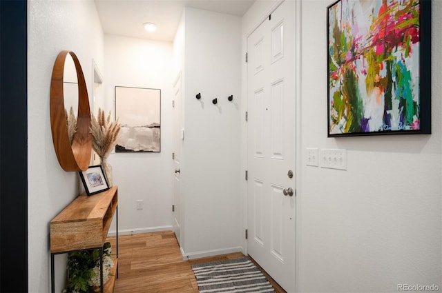 doorway featuring baseboards and wood finished floors