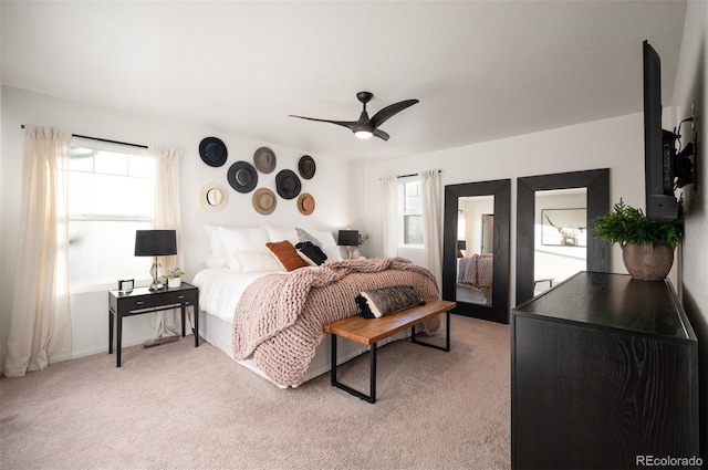 bedroom featuring light carpet and a ceiling fan