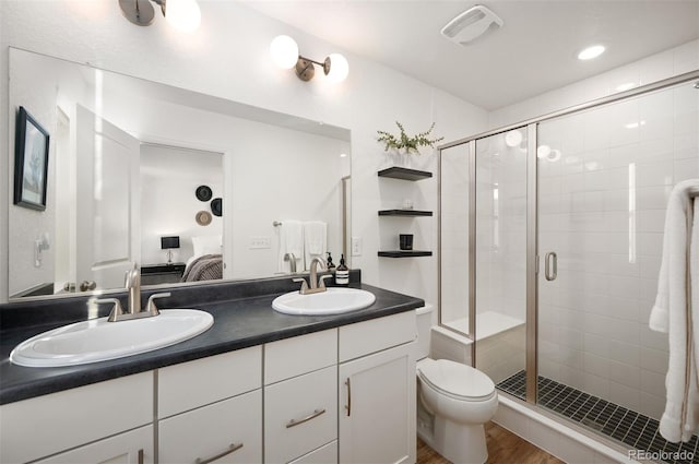 bathroom featuring connected bathroom, visible vents, a sink, and wood finished floors