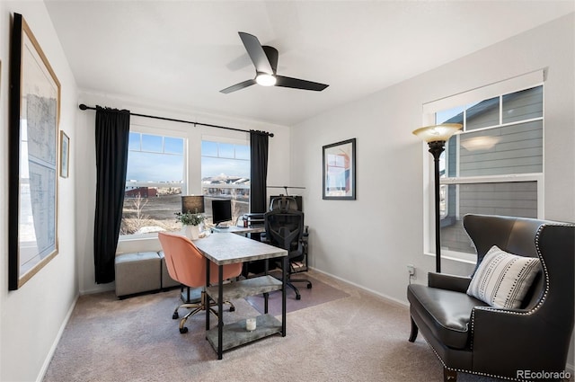 home office with baseboards, a ceiling fan, and light colored carpet