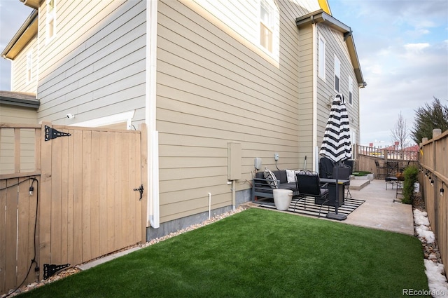 view of property exterior with a yard, outdoor lounge area, a patio area, and a fenced backyard